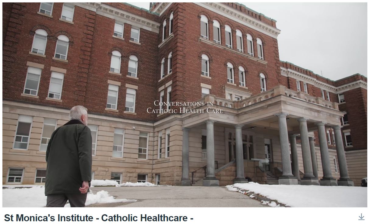 A man walks thoughtfully toward a Catholic Hospital